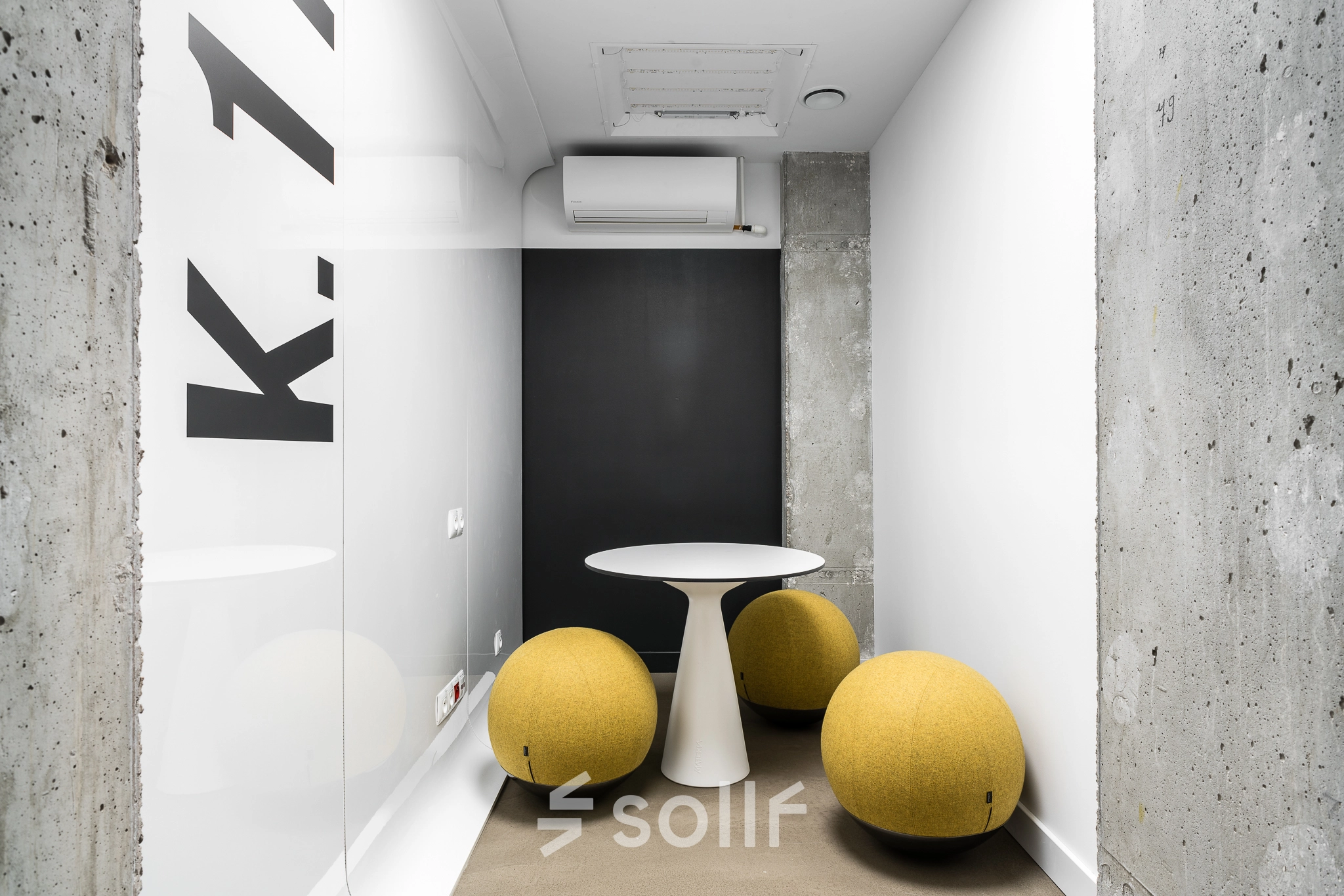 A compact meeting area at Konstruktorska 11 in Warsaw Mokotow with a modern white table and round yellow seats ideal for office space rental.