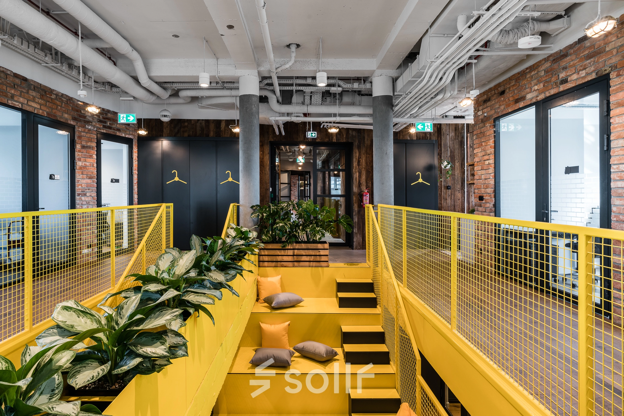 Bright and modern office to rent at Konstruktorska 11 in Warsaw Mokotow, featuring yellow accents, greenery, and an inviting work environment.