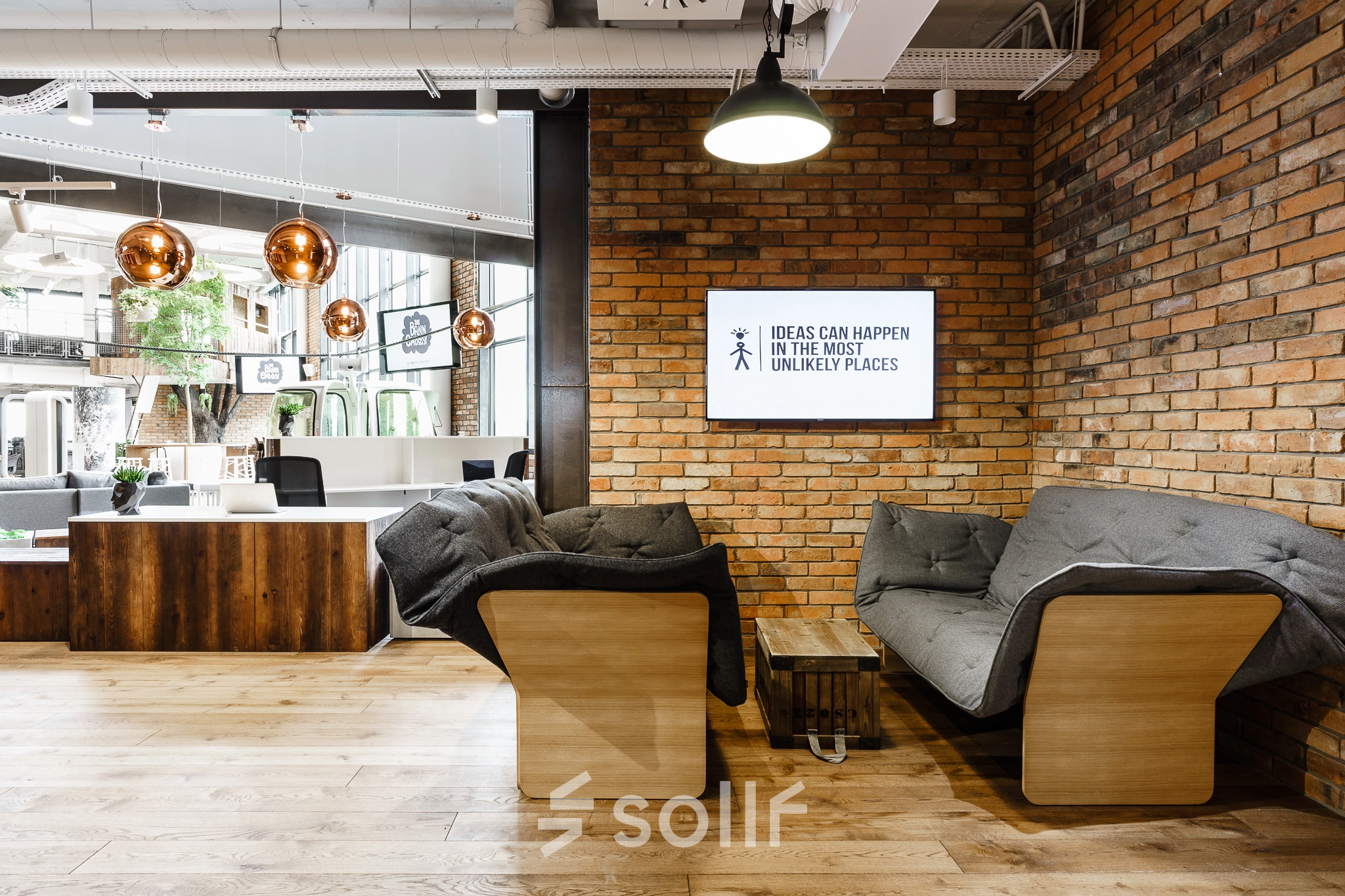 Cozy office space with modern furniture, exposed brick walls, and a shared seating area at Al. Jerozolimskie 181B, Warsaw Ochota. Ideal for office space rental.