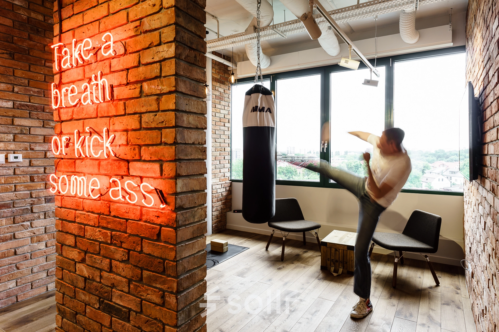 Office space rental at Al. Jerozolimskie 181B, Warsaw Ochota features a modern interior with a punching bag and motivational neon sign, suited for energetic work environments.