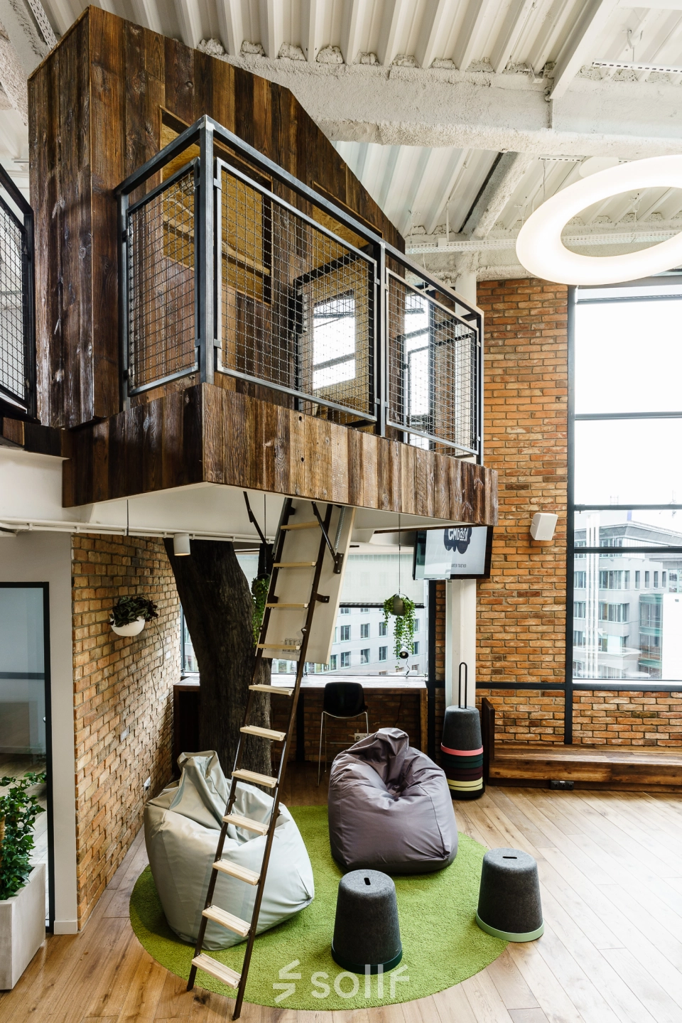 Office space rental at Al. Jerozolimskie 181B features a modern interior with a unique loft-style meeting area and cozy seating, ideal for collaborative activities in Warsaw Ochota.