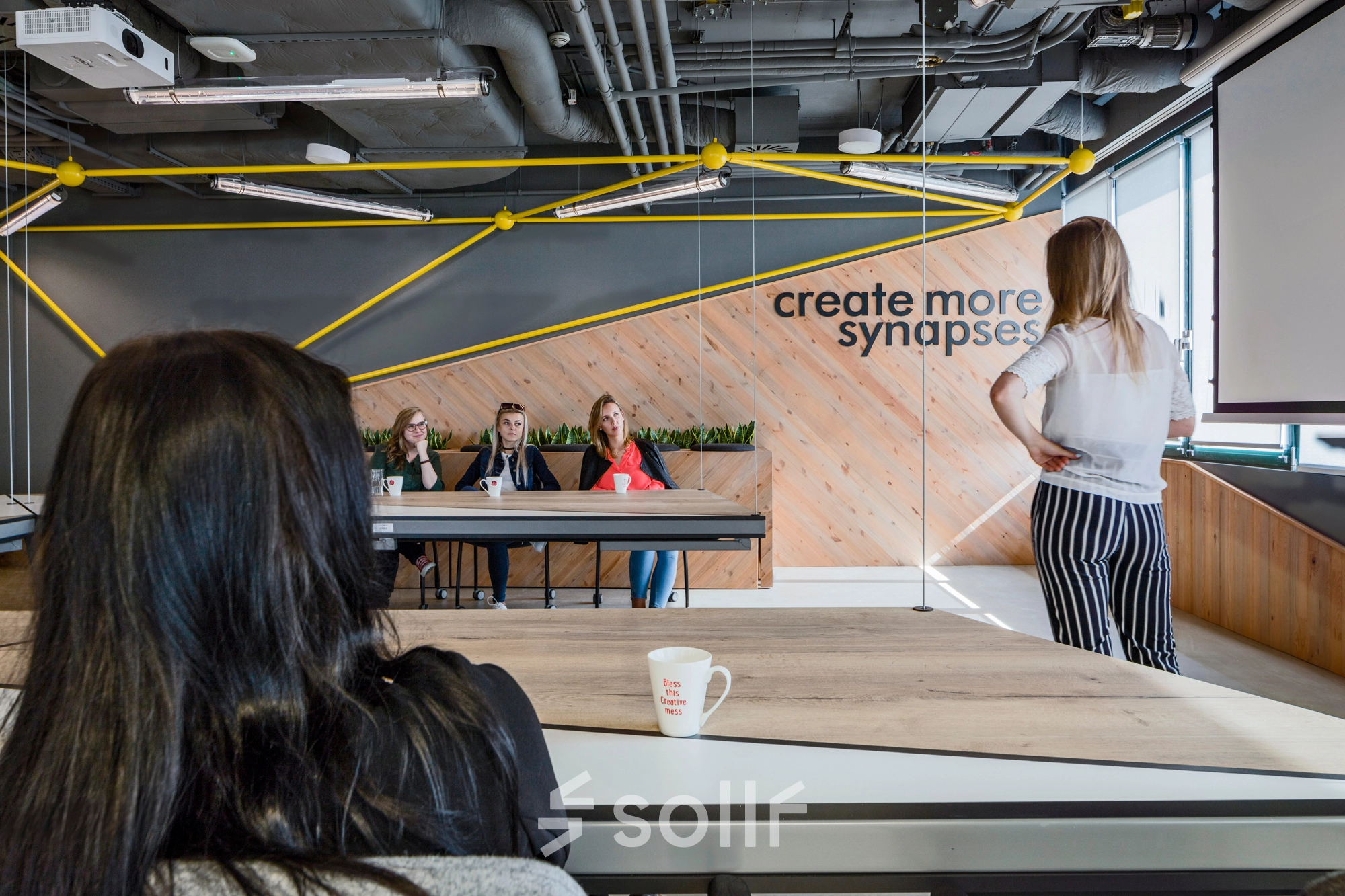 A team engaged in a meeting in a modern office, located at Al. Jerozolimskie 181B, Warsaw Ochota. Ideal for office space rental with collaborative work areas.