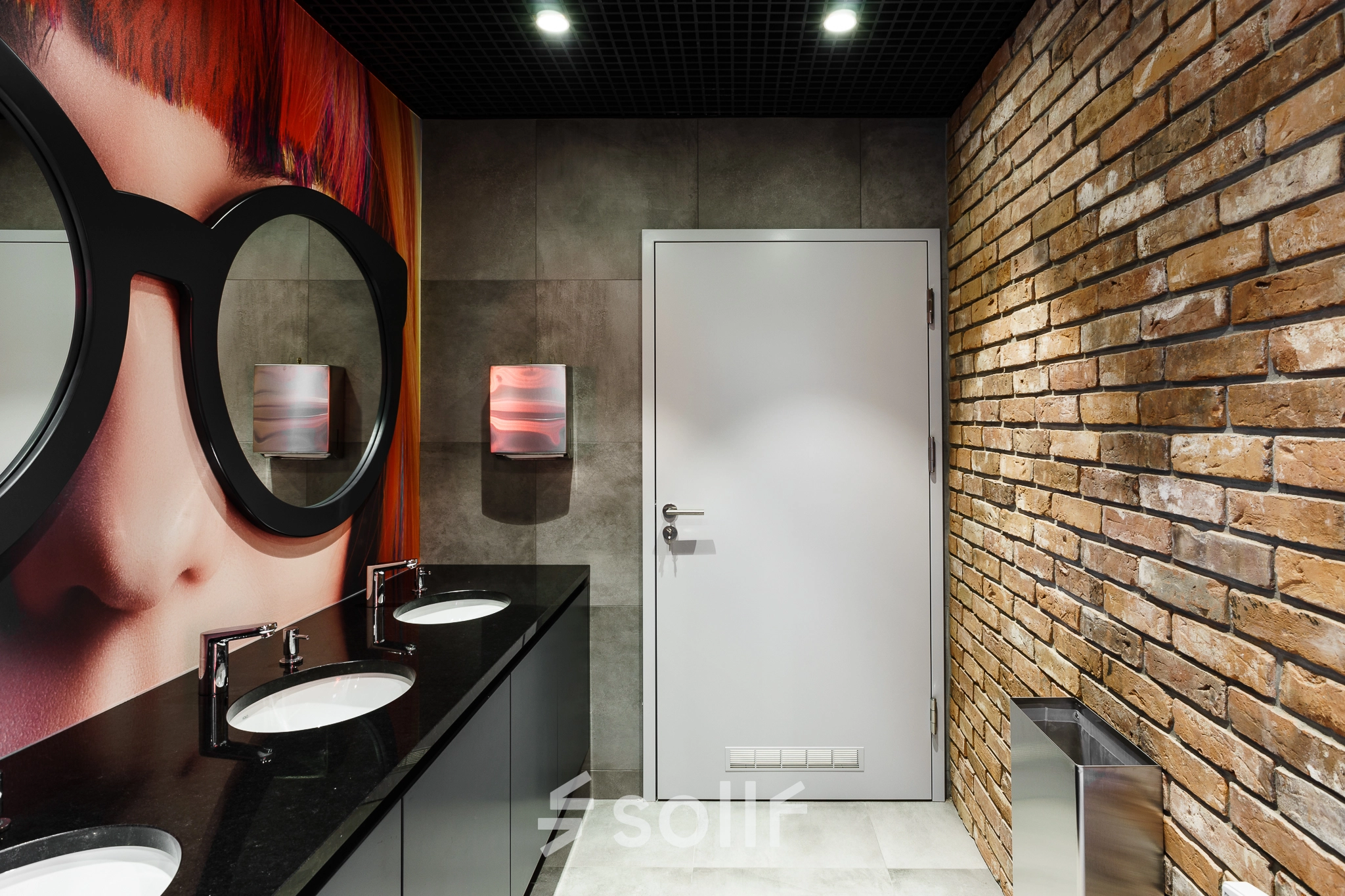 Modern restroom with brick accent wall and stylish decor at Al. Jerozolimskie 181B, Warsaw Ochota, ideal for office space rental.