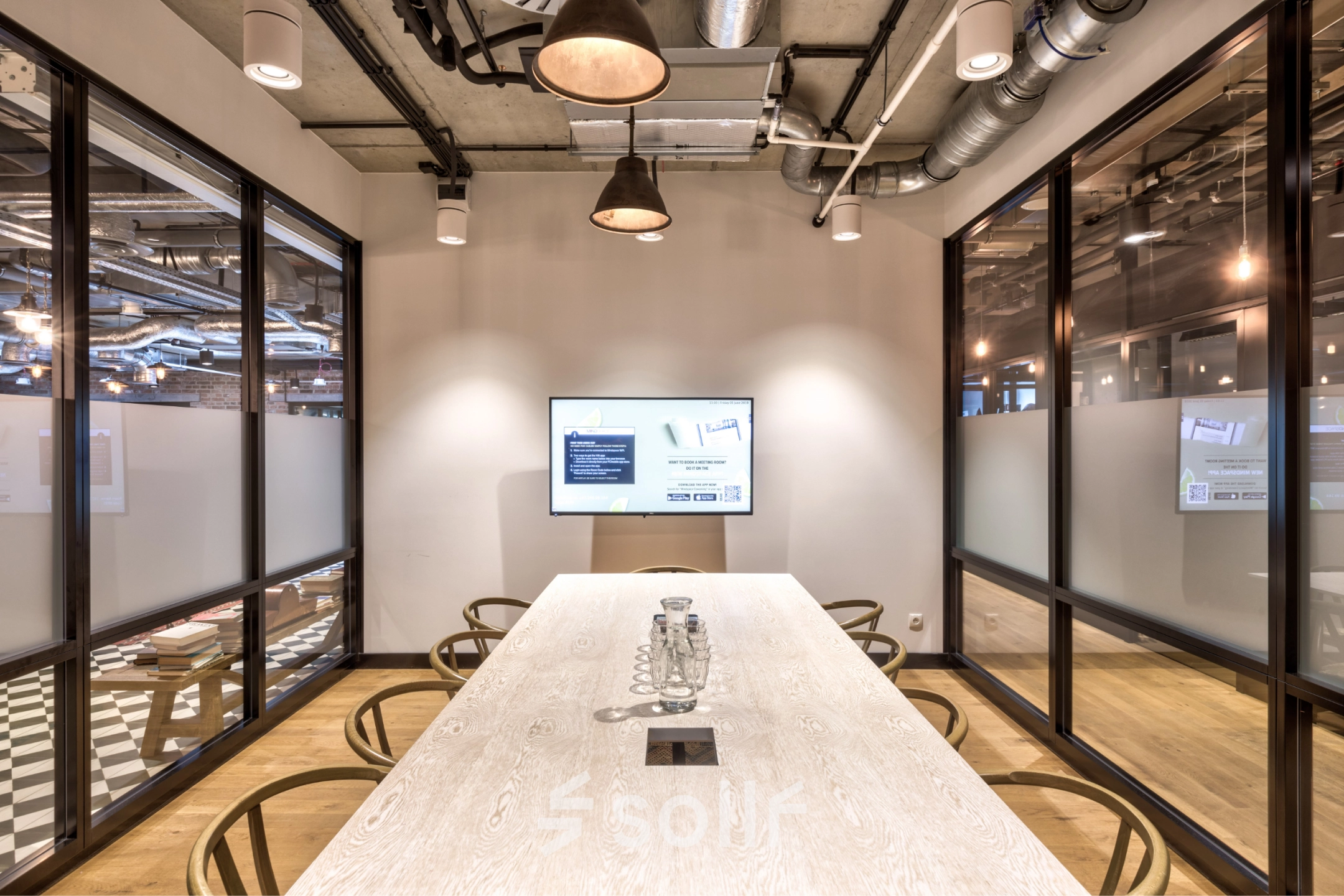 Modern office conference room at Koszykowa 61 in Warsaw Śródmieście, featuring a large table and a screen, ideal for meeting needs. Discover this office space rental opportunity for collaboration.