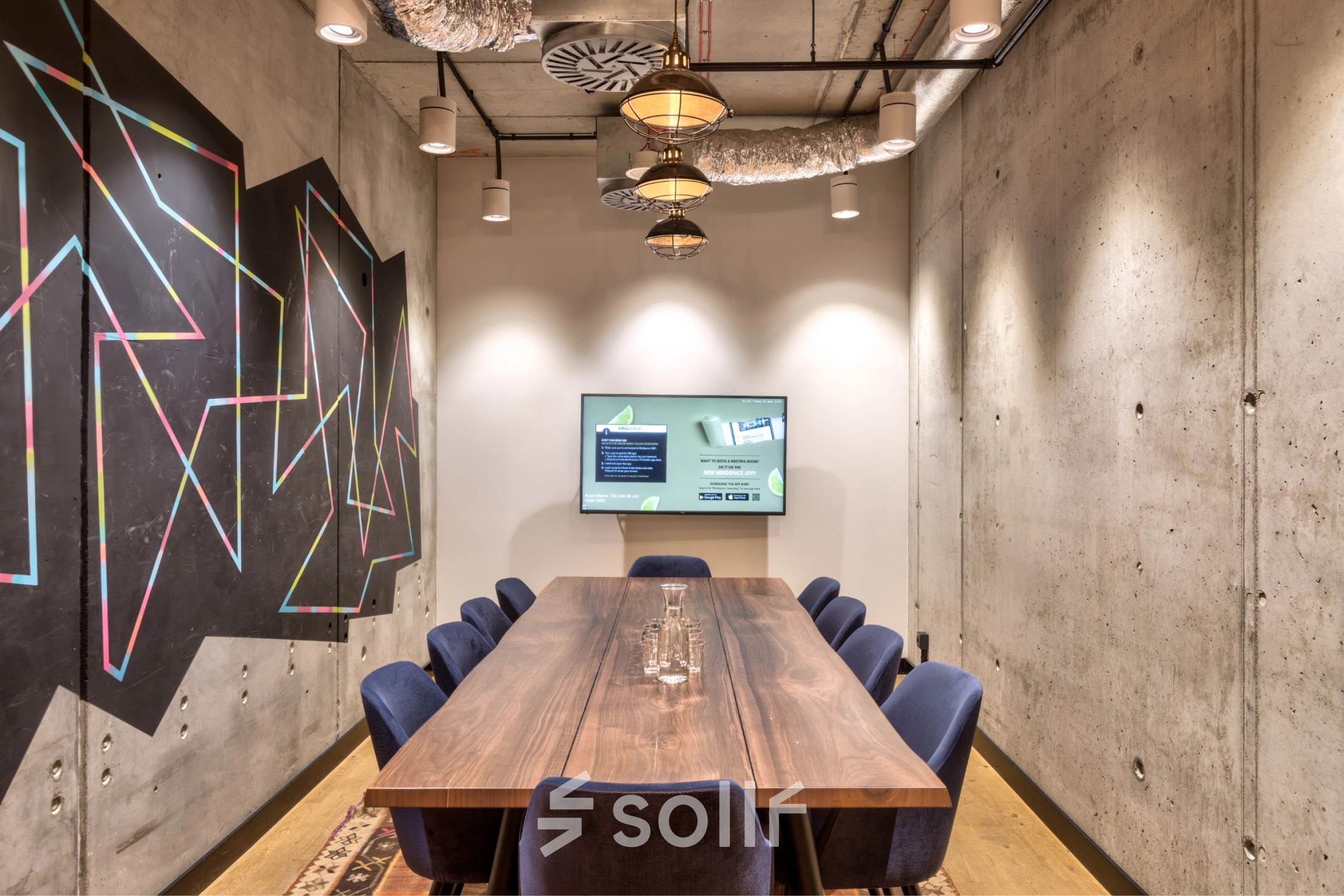 Modern conference room at Koszykowa 61, Warsaw Śródmieście, featuring a large wooden table with blue chairs, ideal for office space rental.