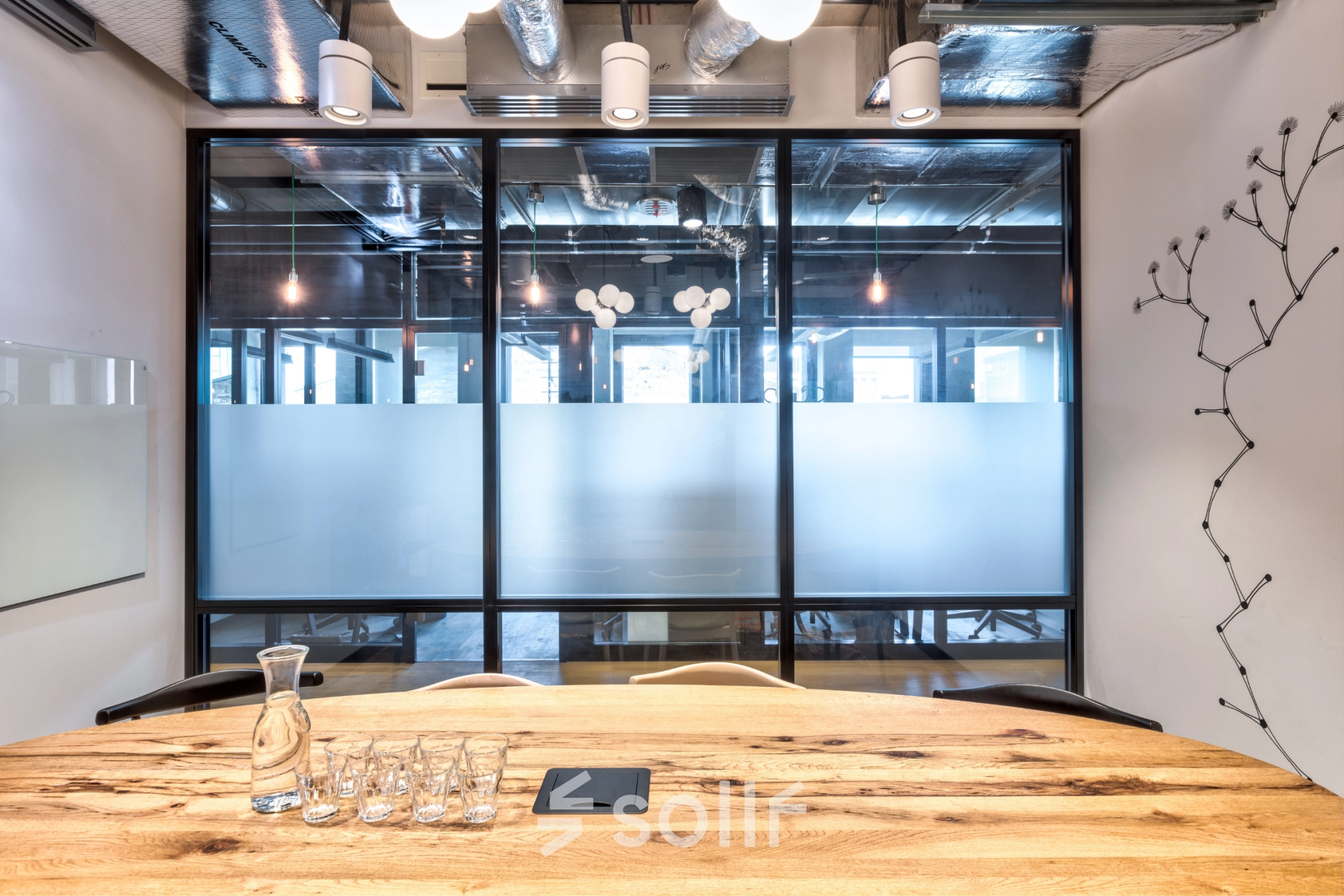 Modern office space at Koszykowa 61, Warsaw Śródmieście, featuring a wooden table and glass partition, ideal for office space rental.