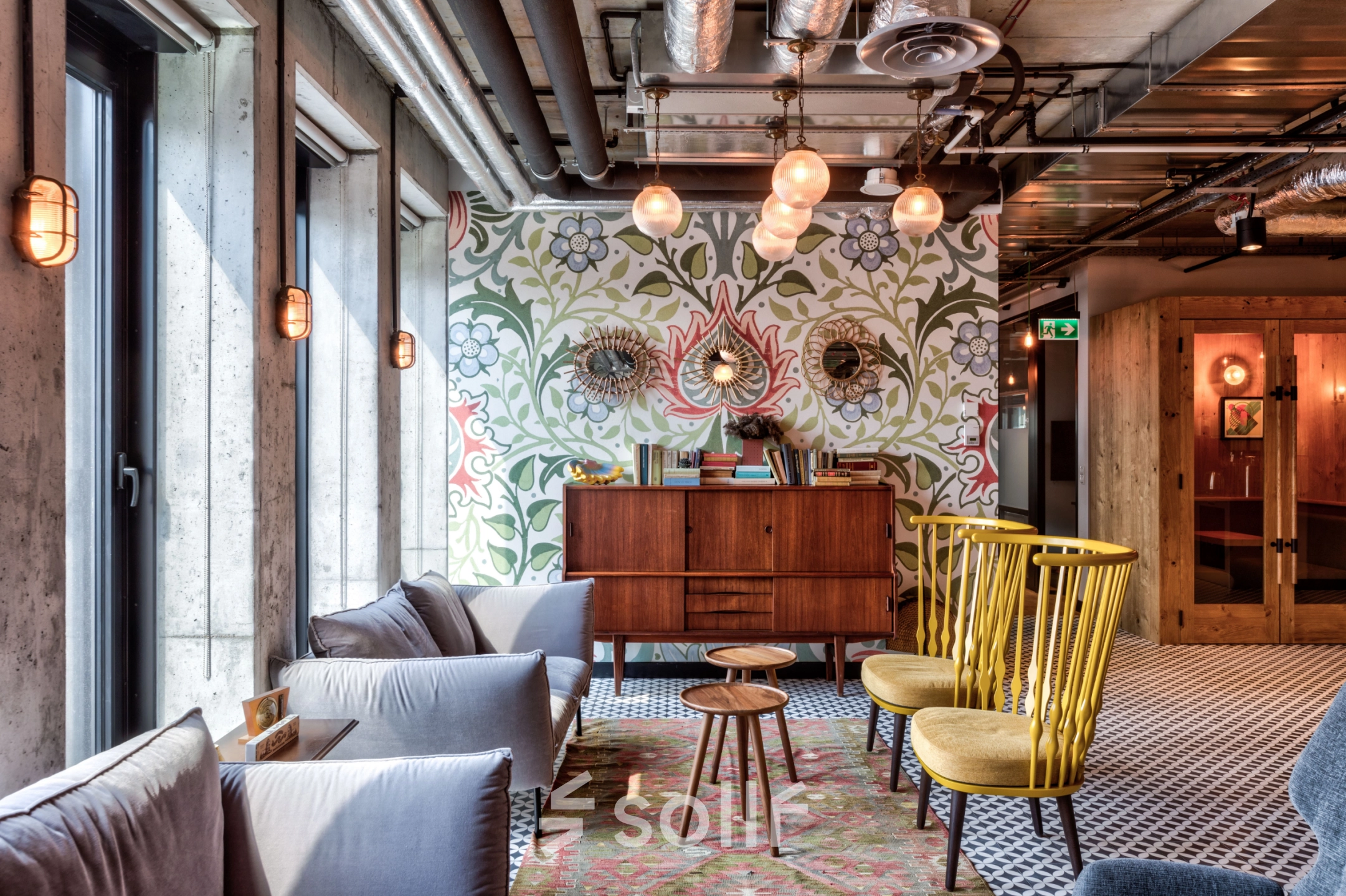 Stylish office space at Koszykowa 61, Warsaw Śródmieście with cozy seating, patterned walls, and modern lighting, perfect for office space rental.