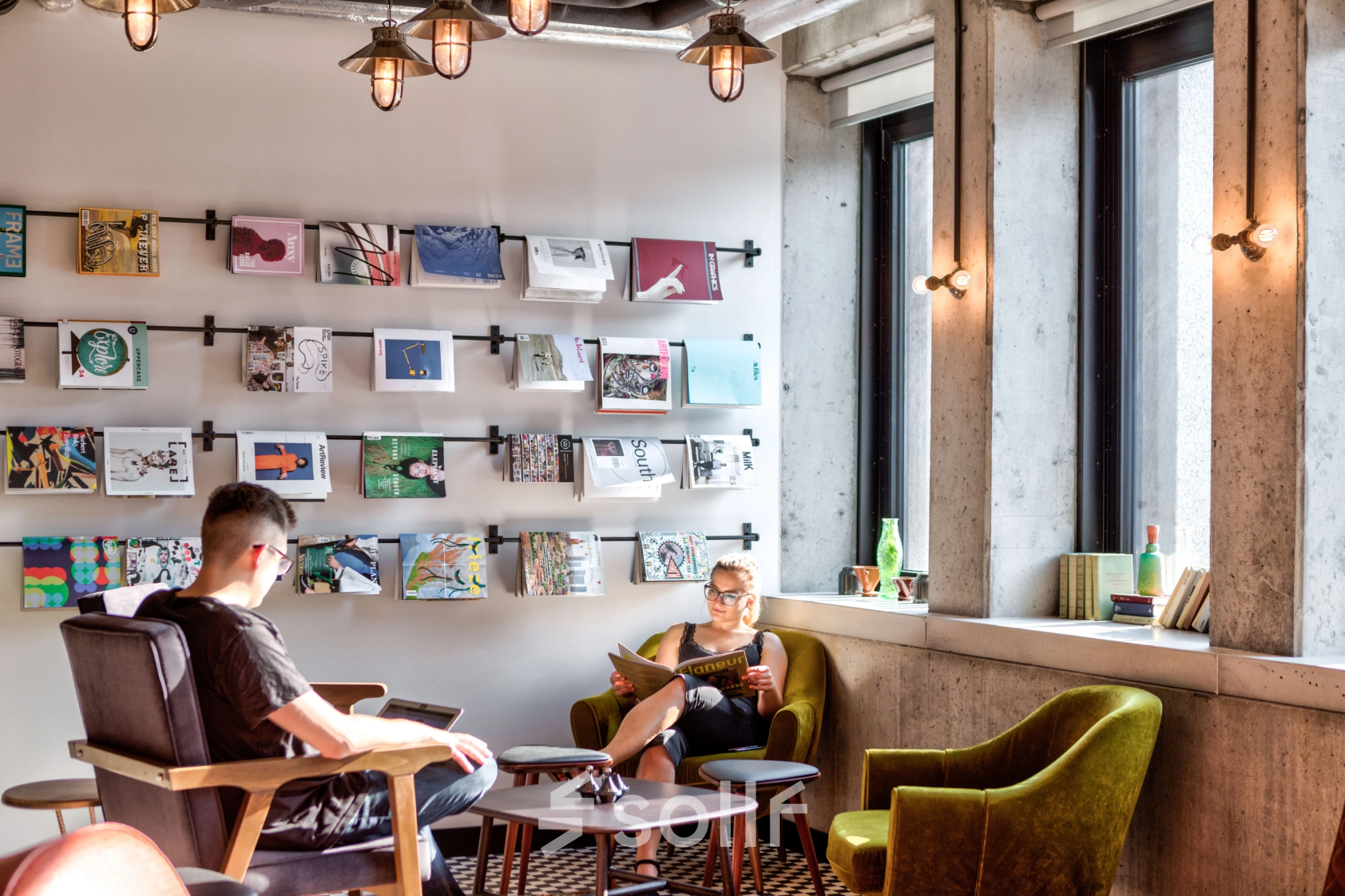 Two people relax in a cozy lounge area with modern decor at an office space rental on Koszykowa 61, Warsaw Śródmieście.
