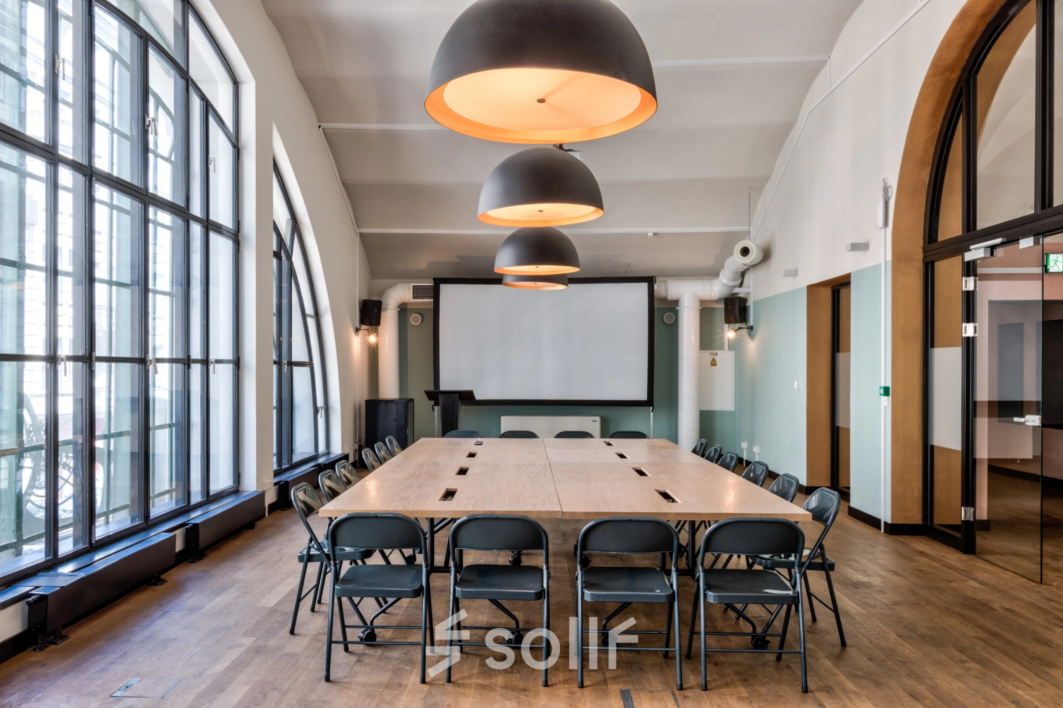 Spacious conference room available for office space rental at Koszykowa 61, Warsaw Śródmieście. Elegant lighting and a large table set-up create a professional environment for meetings and discussions.