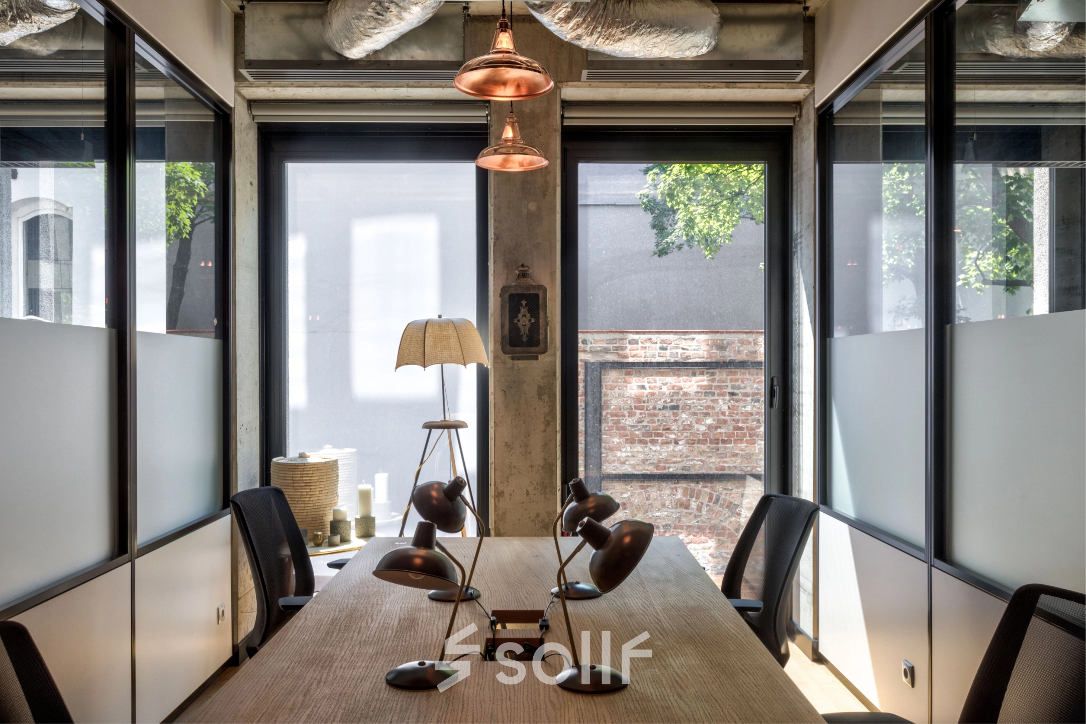 Modern office space on Koszykowa 61 in Warsaw Śródmieście with a large table and stylish lamps, ideal for meetings. A perfect office to rent for professionals.