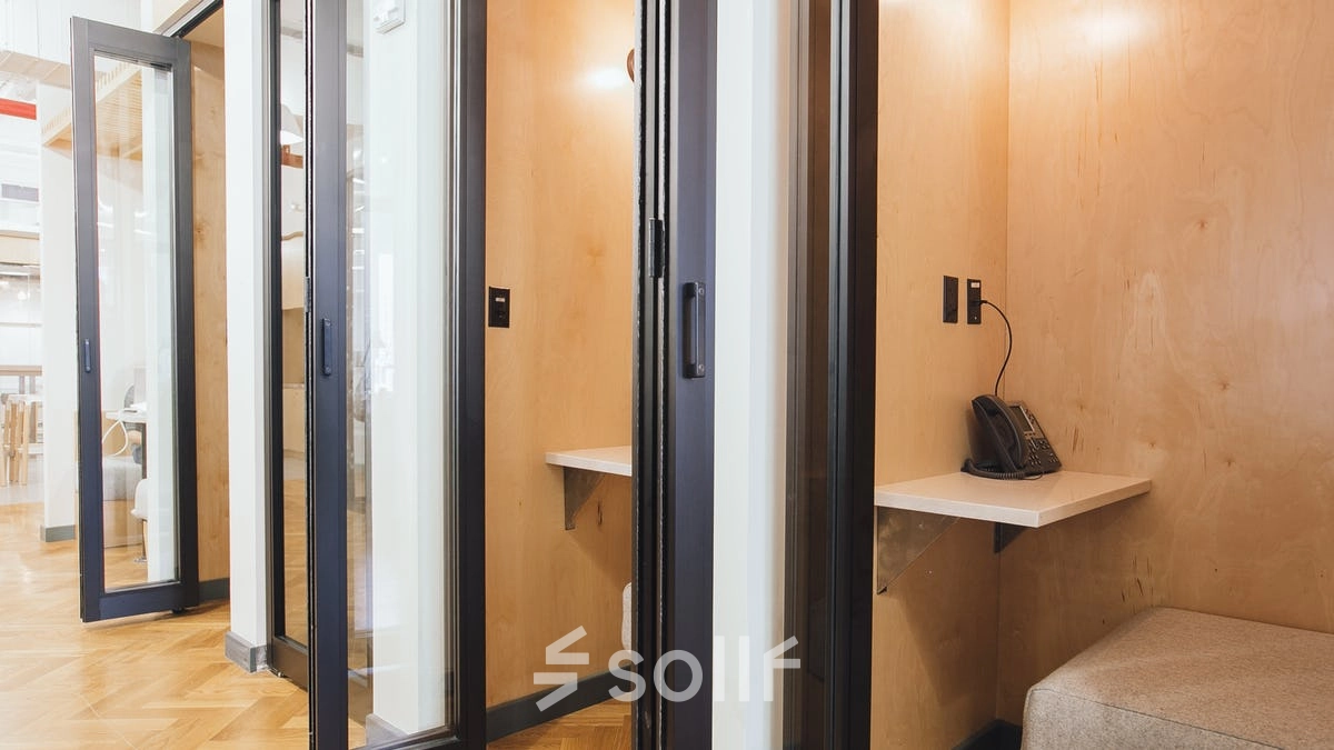 Interior view of furnished office space at Krakowskie Przedmieście 13, Warsaw Śródmieście, showcasing individual work booths with phones, ideal for office space rental.