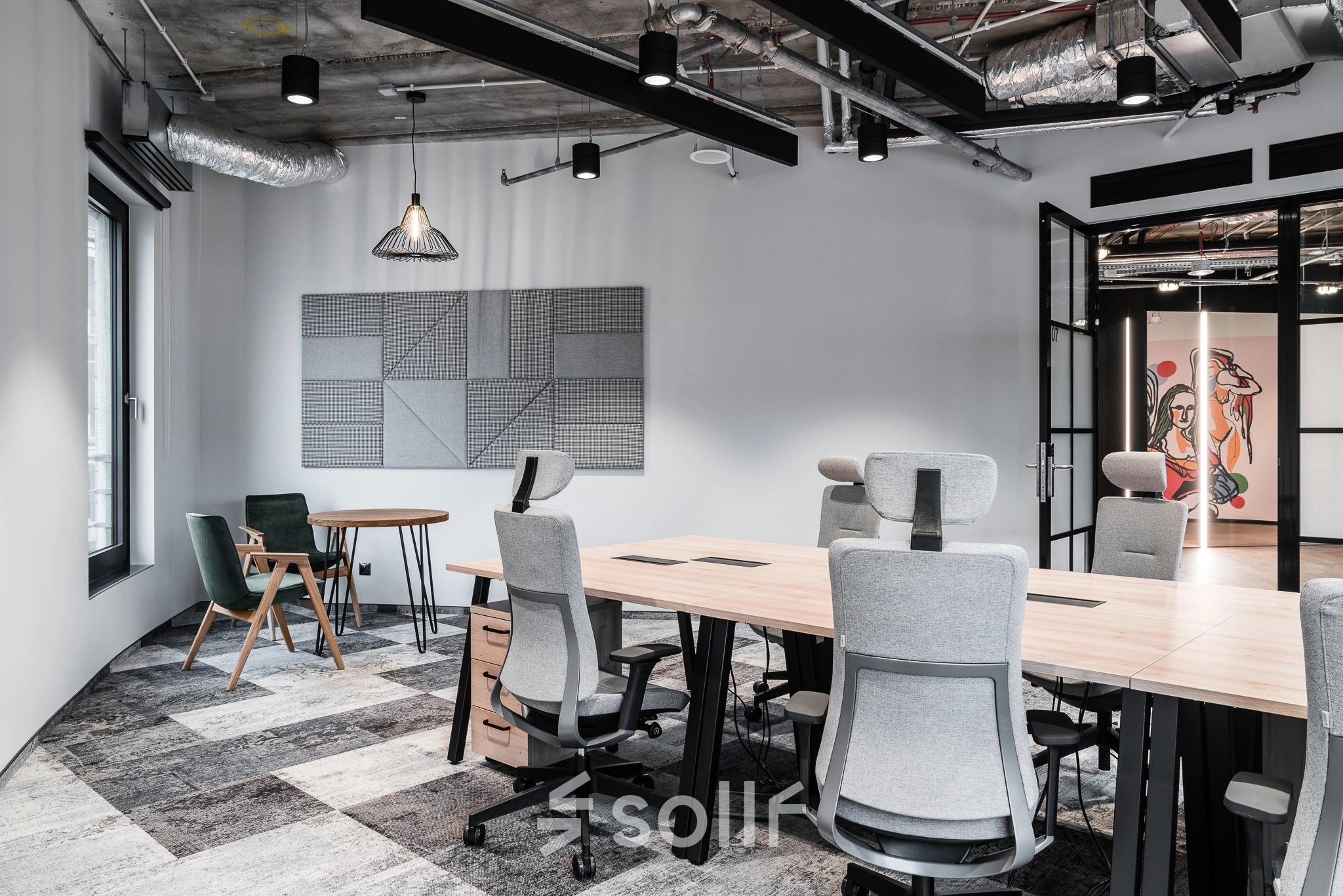 A modern furnished office space in Warsaw's Śródmieście at Plac Trzech Krzyży 10/14, featuring stylish workstations under exposed ceilings, ideal for office space rental.