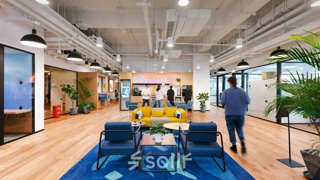 Modern workspace at Grzybowska 60, Warsaw Wola, featuring contemporary furniture and individuals engaged in collaborative business activities.
