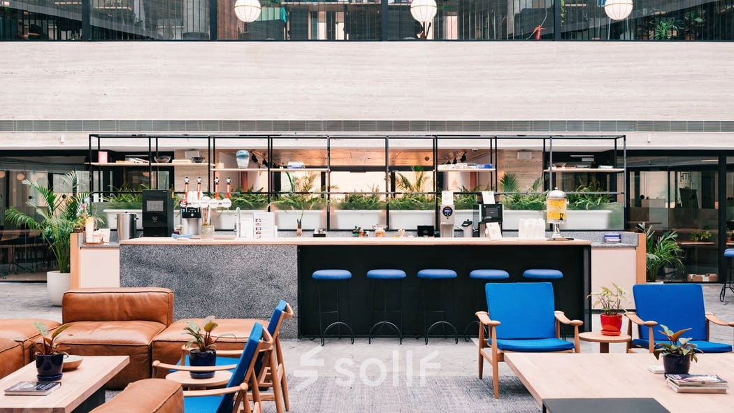 Modern office lounge with a central bar at Grzybowska 60, Warsaw Wola, ideal for office space rental.