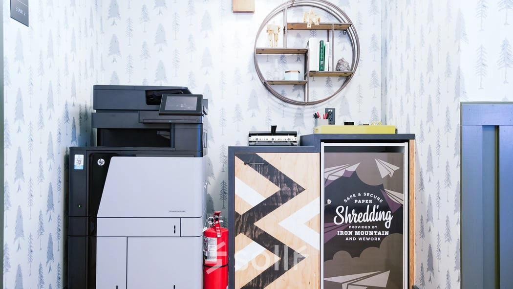 Furnished office space rental at Grzybowska 60 in Warsaw Wola featuring printing equipment and decorative shelving.