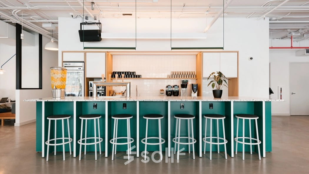 A modern, furnished office space with a long counter and stools, located at Rondo Daszyńskiego 2 in Warsaw Wola, available for rent office space.
