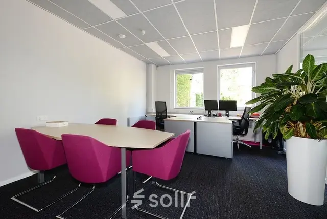 Bright office space at Molenweer 2, Wateringen, featuring modern desks, vibrant chairs, and large windows. Ideal for those seeking office space rental with natural light.