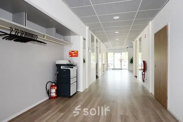 Bright hallway at Molenweer 2, Wateringen, featuring a printer and coat rack, ideal for anyone looking to rent office space.
