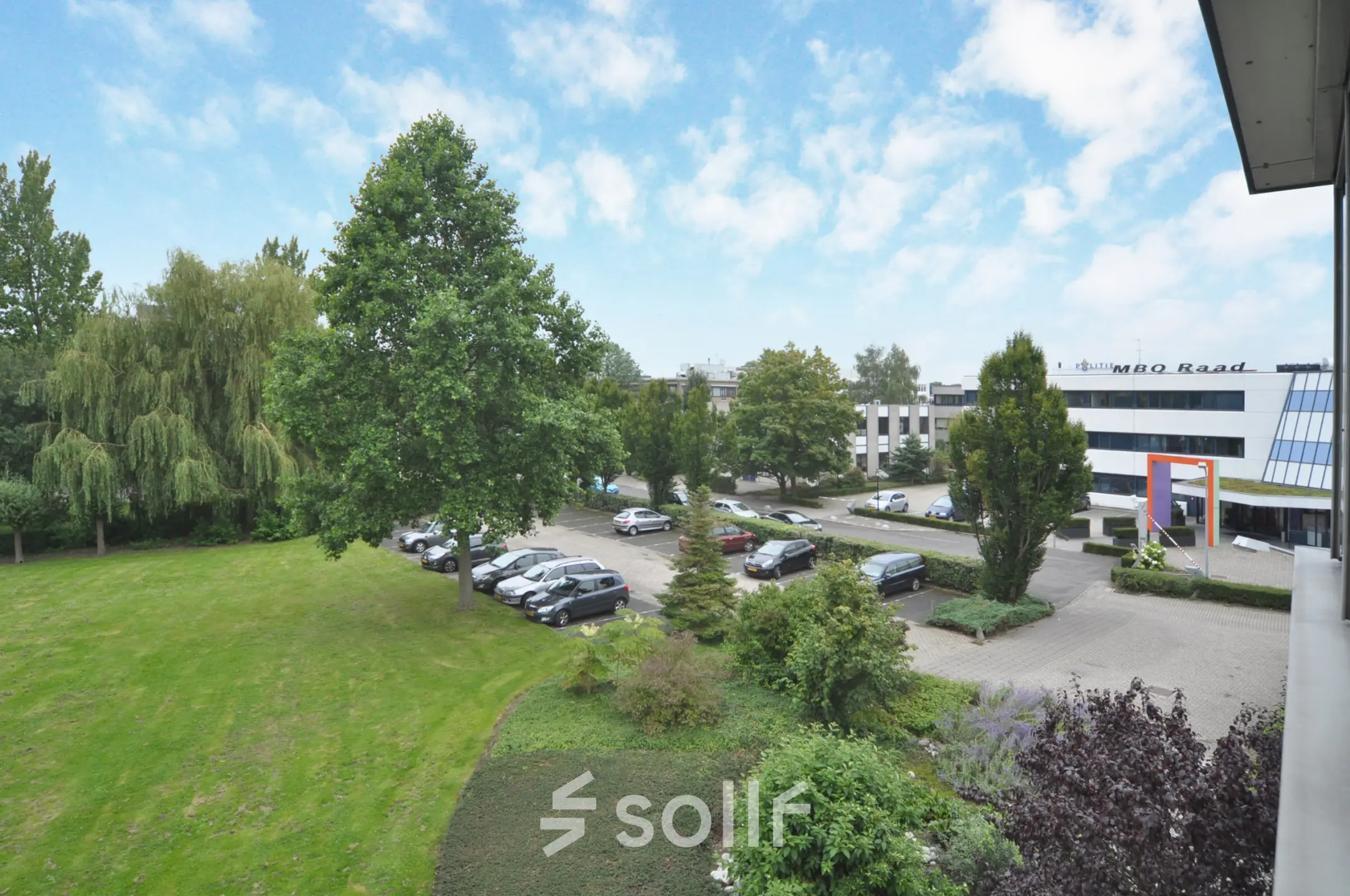 View of the office building and parking area at Houttuinlaan 4, Woerden, ideal for office space rental.