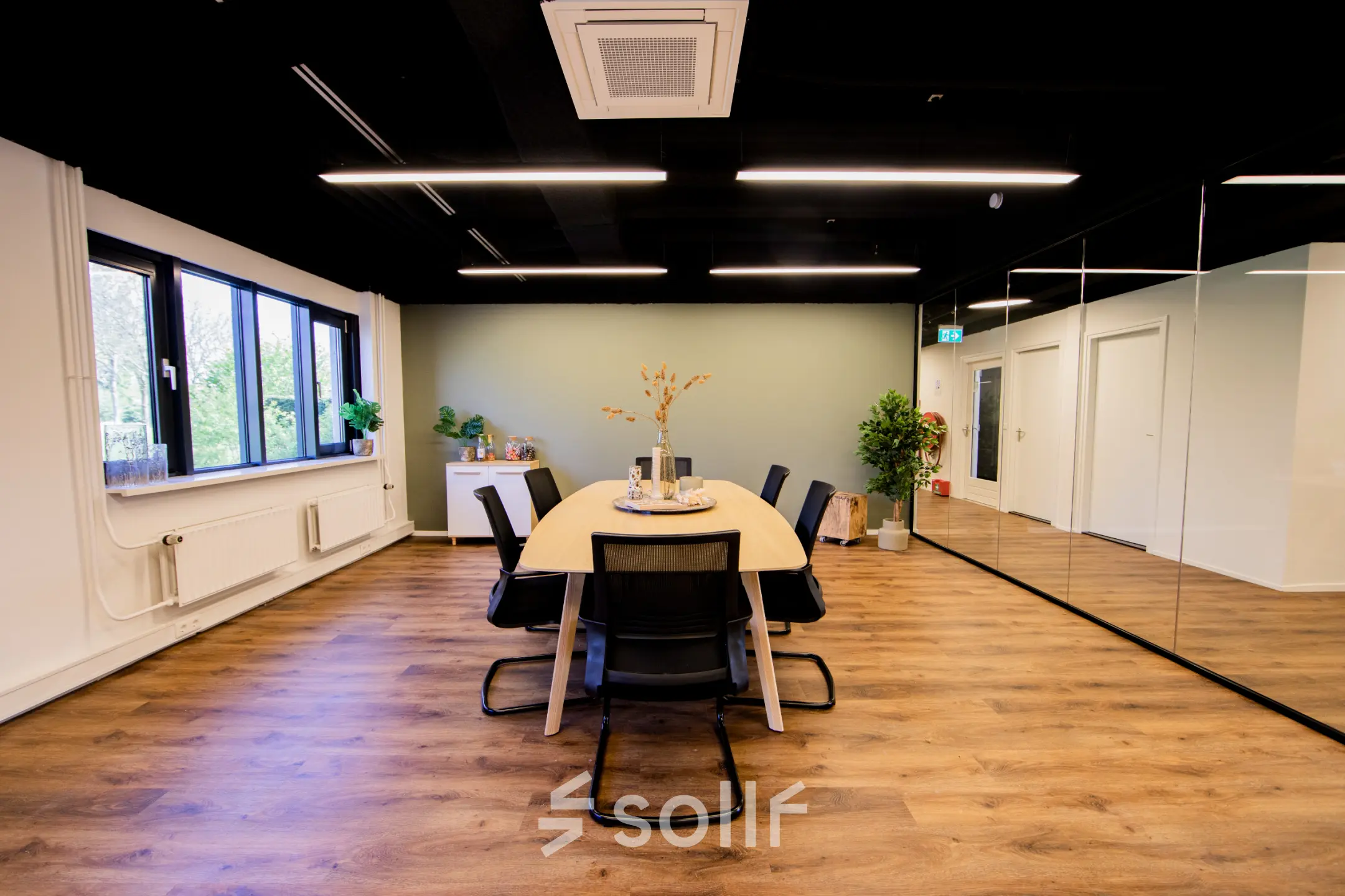 Bright office space rental at Pelmolenlaan 16, Woerden, featuring a sleek meeting table surrounded by chairs and subtle decor elements.