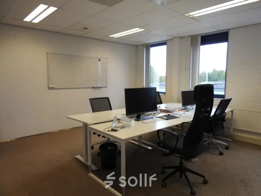 Interior office space at Pompmolenlaan 9, Woerden, featuring a furnished workspace with desks, chairs, and computer monitors, ideal for office space rental.