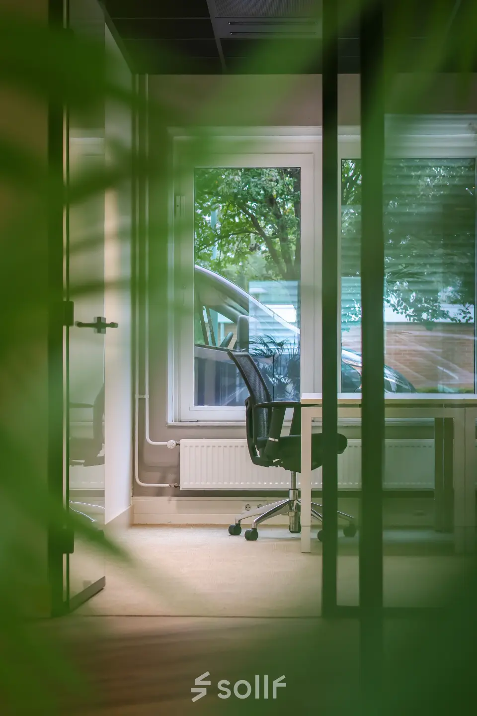 Bright office space for rent at Vijzelmolenlaan 9, Woerden, featuring a modern desk and chair facing a window with outdoor views.