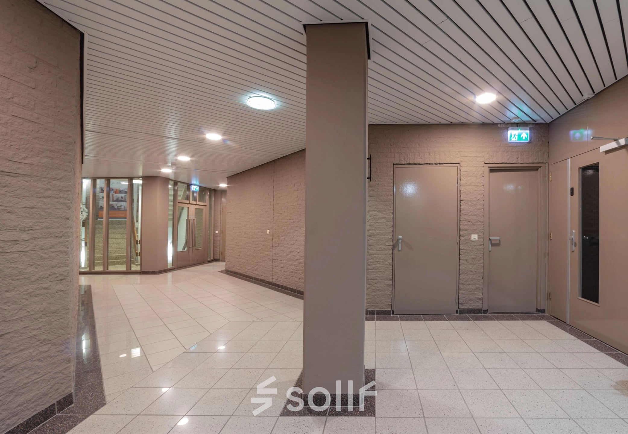 Interior view of an office space for rent at Zaagmolenlaan 4, Woerden featuring a hallway with tiled floors and beige walls.