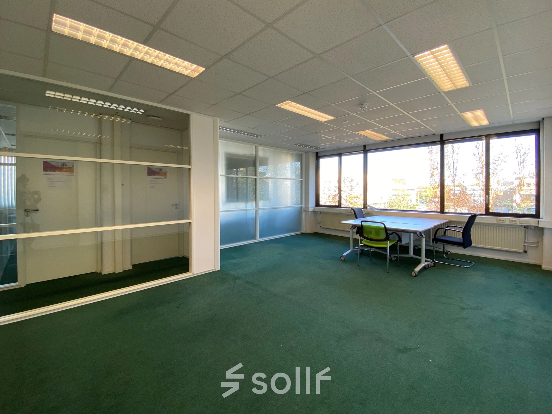 Spacious office space for rent at Zaagmolenlaan 4, Woerden, featuring large windows and table with chairs, ideal for business activities.