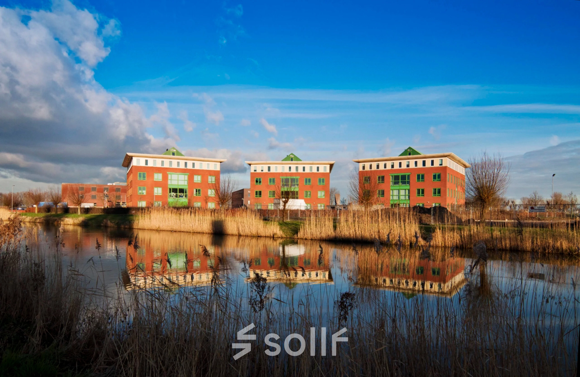 Exterior view of office buildings at Mercurion 24, Zevenaar, featuring picturesque reflections in a nearby body of water. Ideal for office space rental opportunities.