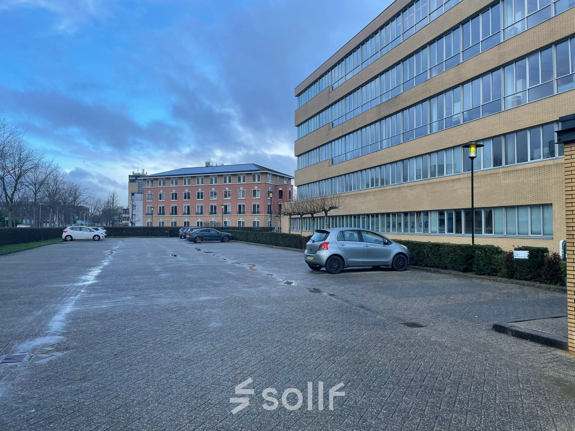 Exterior view of office building at Baron de Coubertinlaan 35 in Zoetermeer, featuring spacious parking area for office space rental.