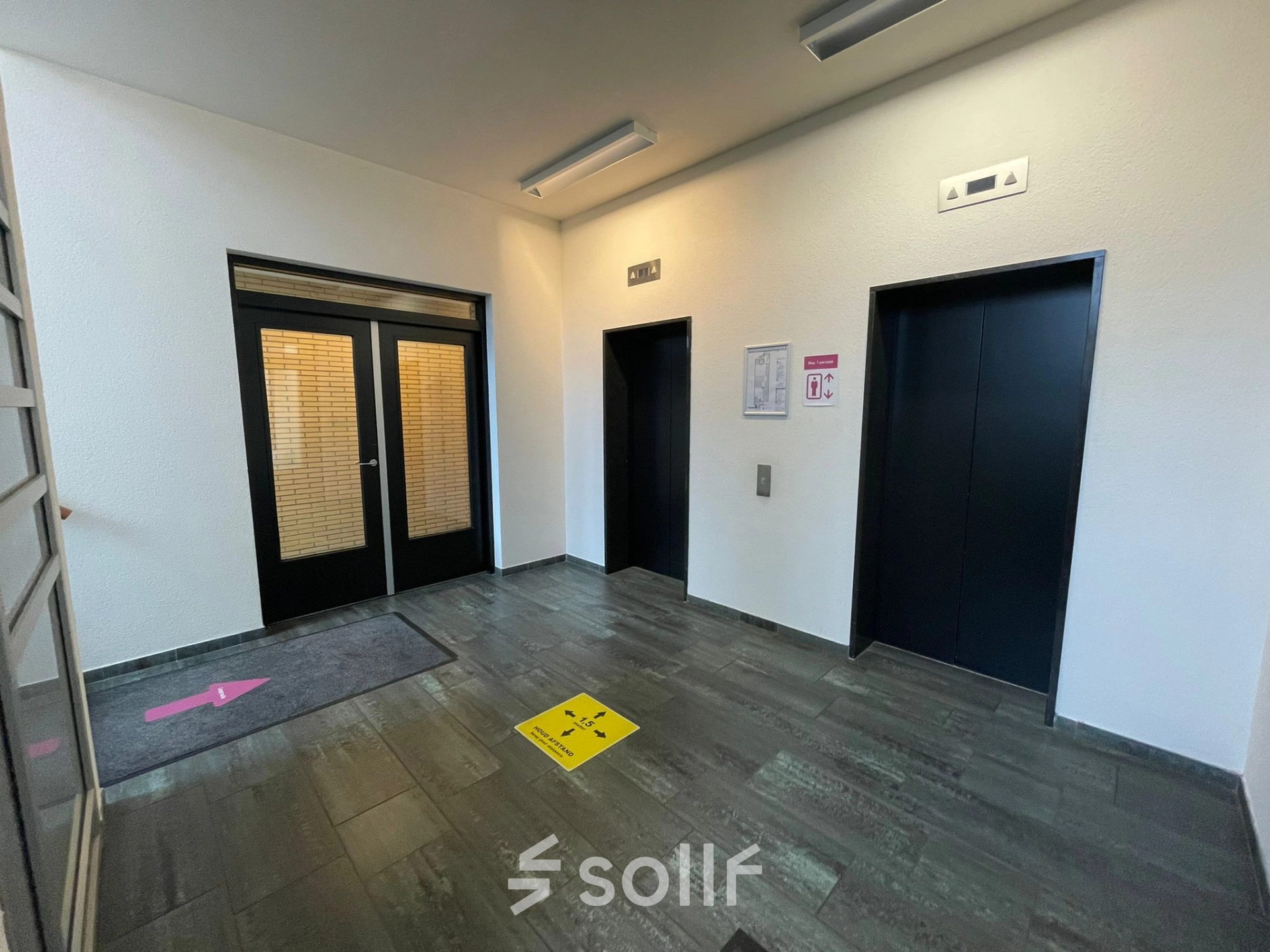 Office entrance area at Baron de Coubertinlaan 35, Zoetermeer, shown with elevators and directional signs, ideal for office space rental needs.