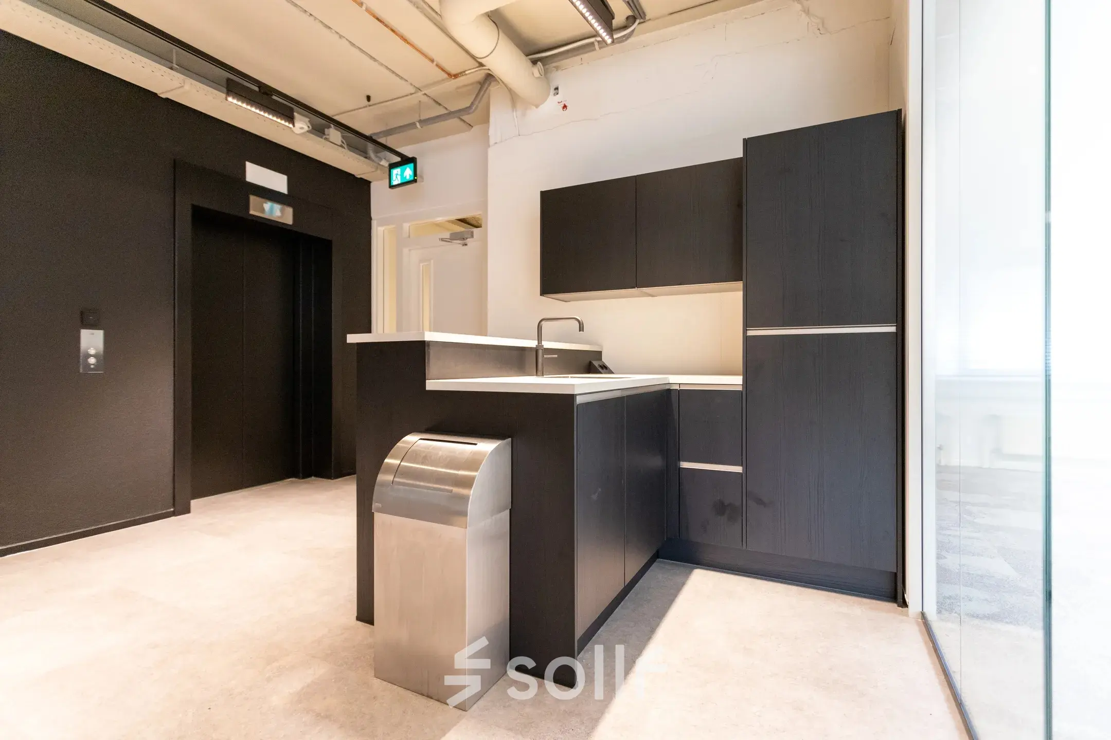 Modern office kitchenette with dark cabinetry at Boerhaavelaan 40, Zoetermeer, available for office space rental.