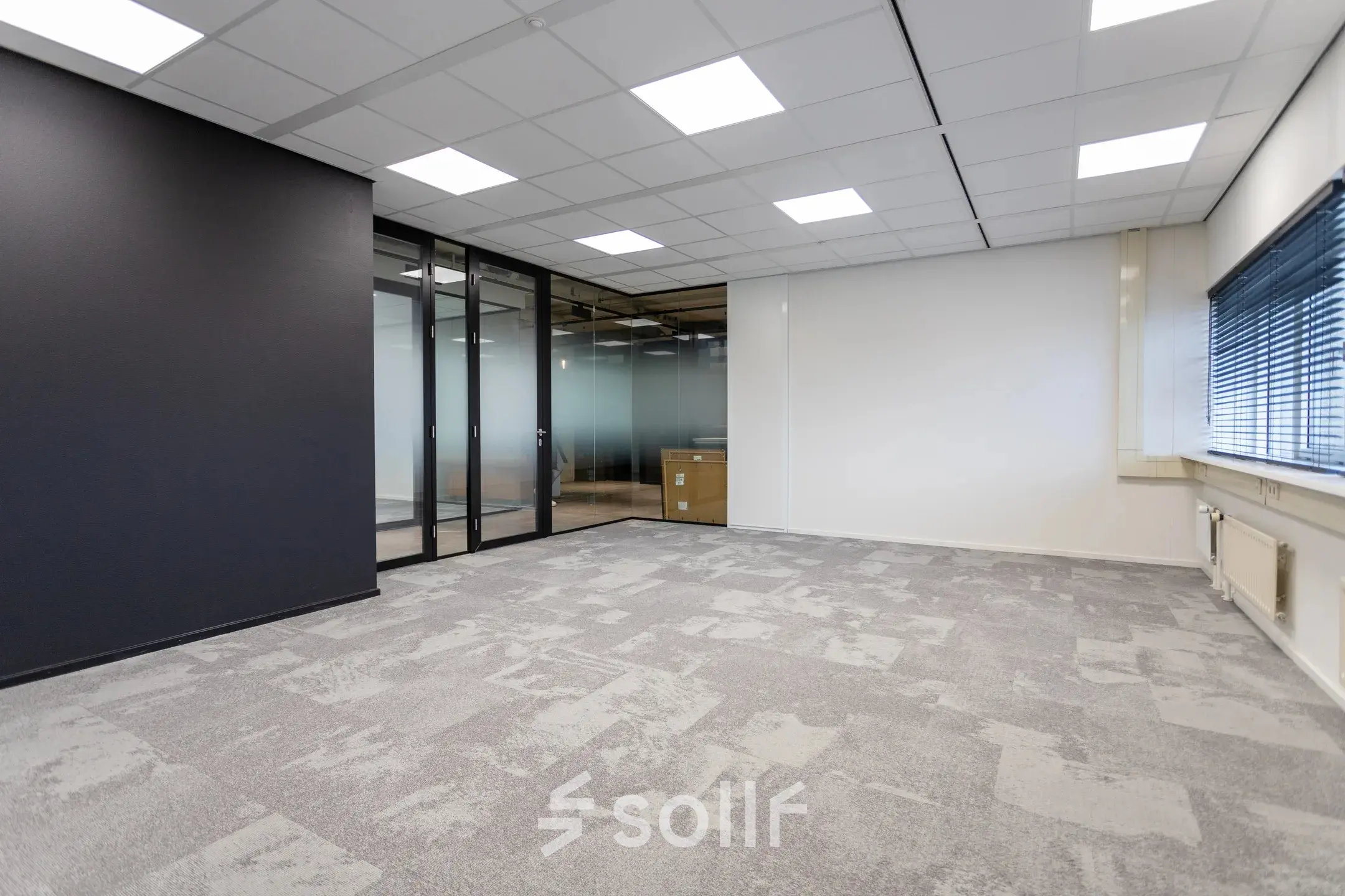 Spacious office to rent at Boerhaavelaan 40, Zoetermeer, featuring sleek glass partitions and modern ceiling lighting, ideal for setting up your professional workspace.