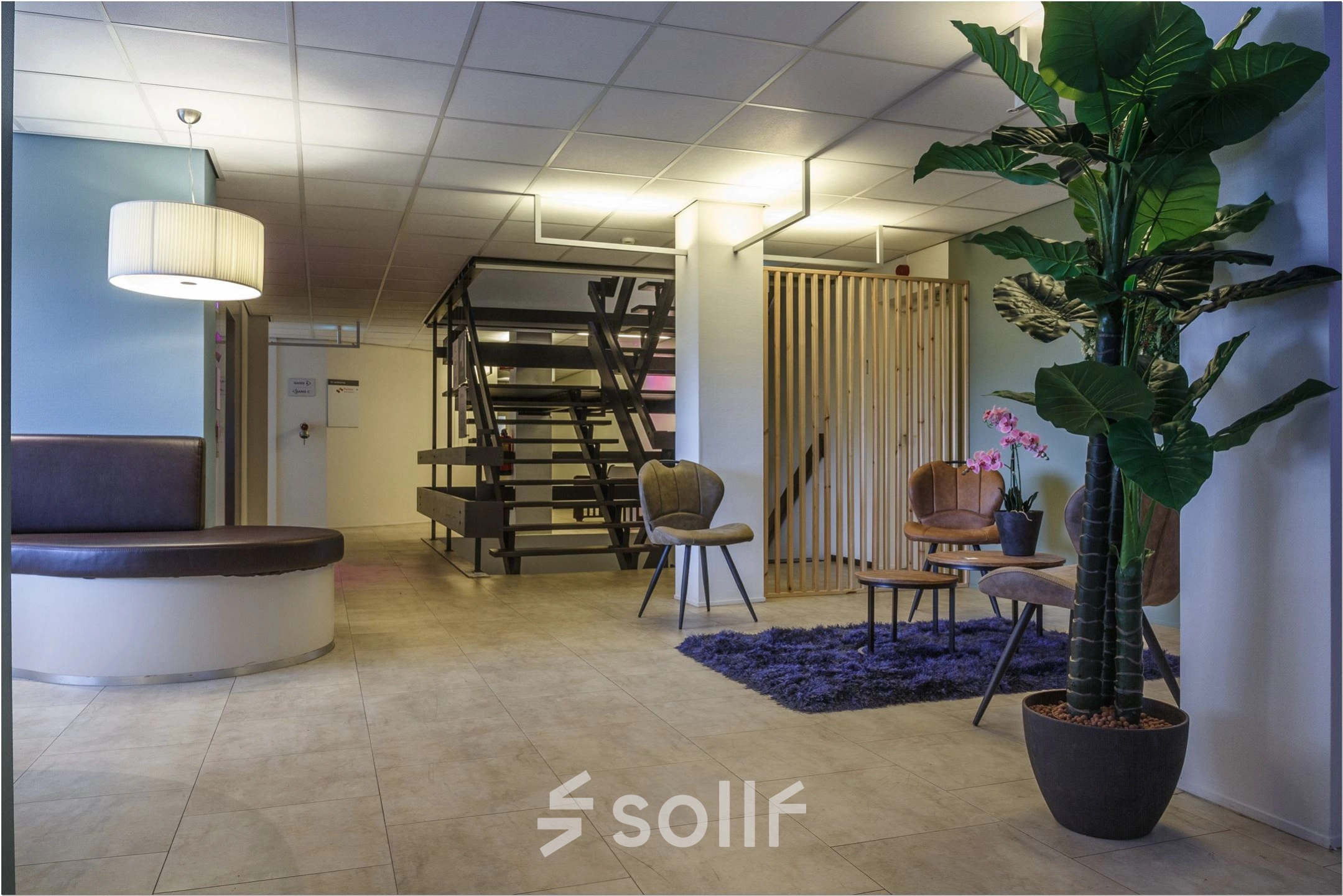 Modern office space lounge at Bredewater 26, Zoetermeer, featuring a chic waiting area with stylish furniture and plants, ideal for rent. Perfect for welcoming clients or informal meetings in a professional setting.