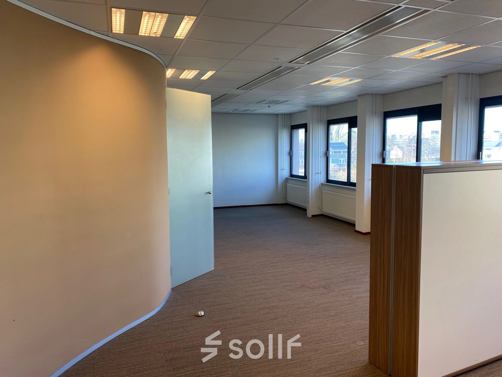 Office space at Bredewater 26, Zoetermeer, featuring a modern layout with carpeted floors and large windows, ideal for office space rental.