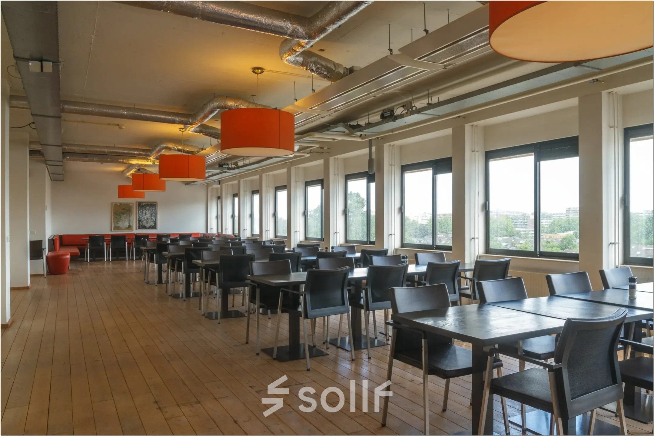 Spacious office interior at Bredewater 26, Zoetermeer featuring rows of tables and chairs, ideal for office space rental. Ample natural light pours in through large windows.