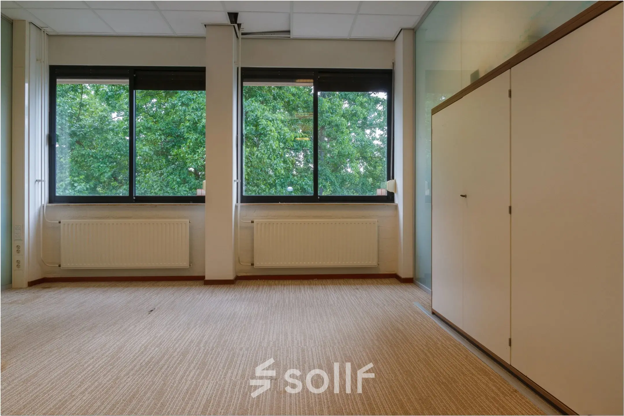 Office space available for rent at Bredewater 26, Zoetermeer, featuring large windows and a built-in storage cabinet.