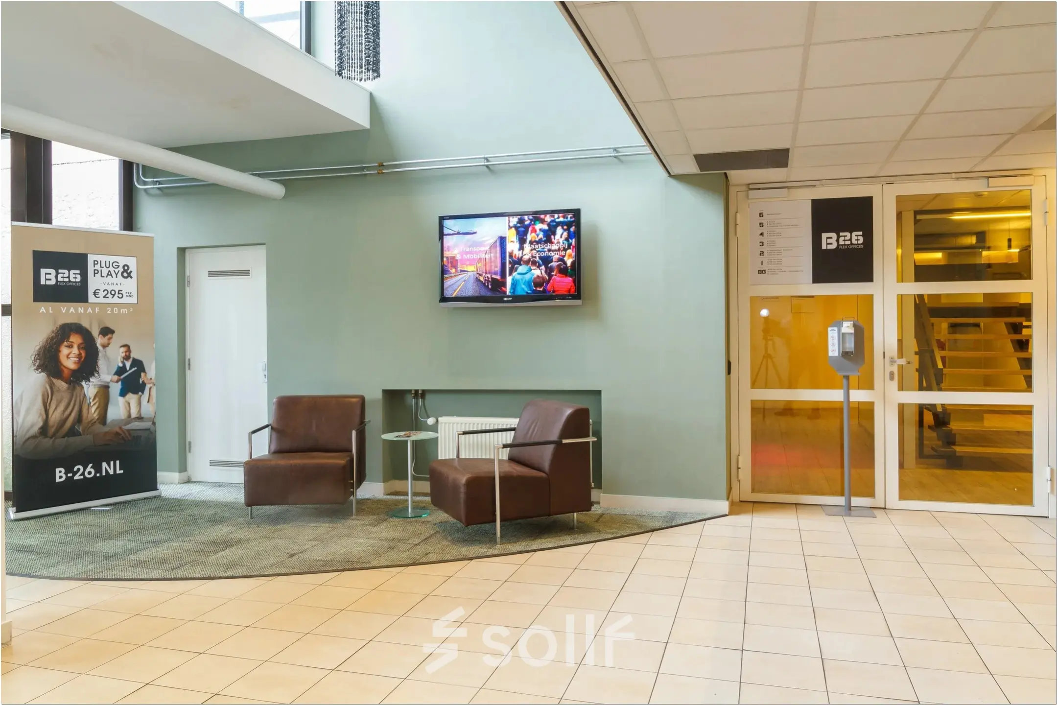 Entrance area at Bredewater 26, Zoetermeer, showing two chairs and a TV, ideal for office space rental.