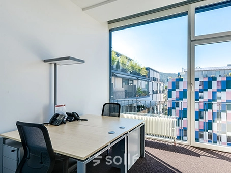 Bright office space at Badenerstrasse 47, Zürich Center with modern furnishings and large windows offering cityscape views, perfect for office space rental.