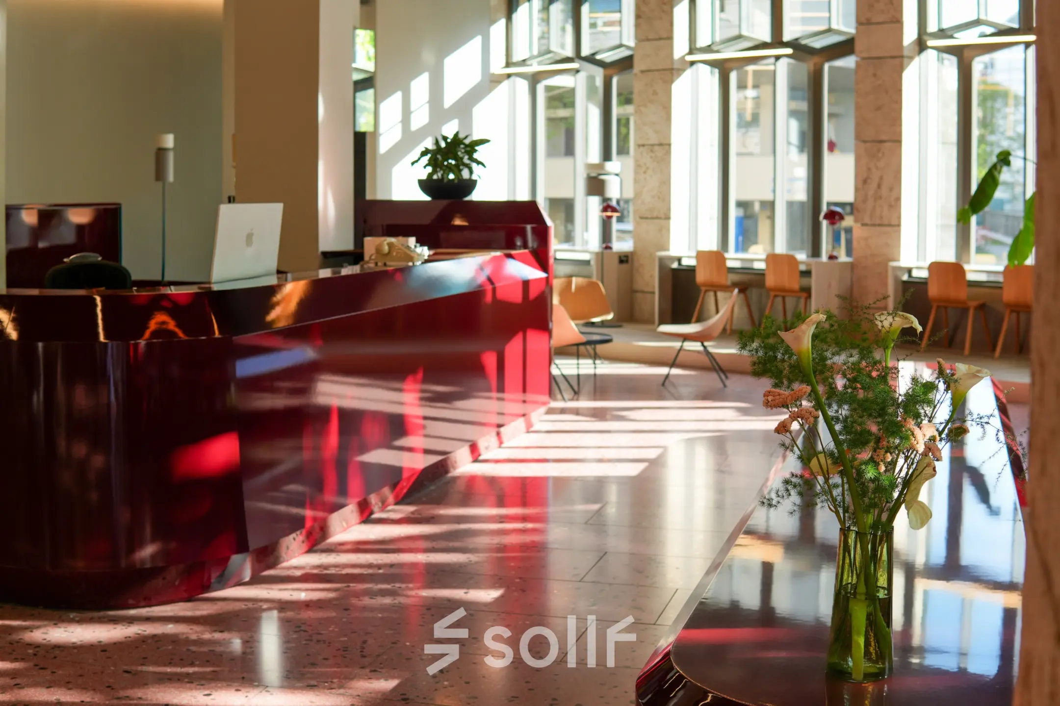 Bright Zürich Center office featuring a glossy reception desk, modern furnishings, and natural light ideal for office space rental.