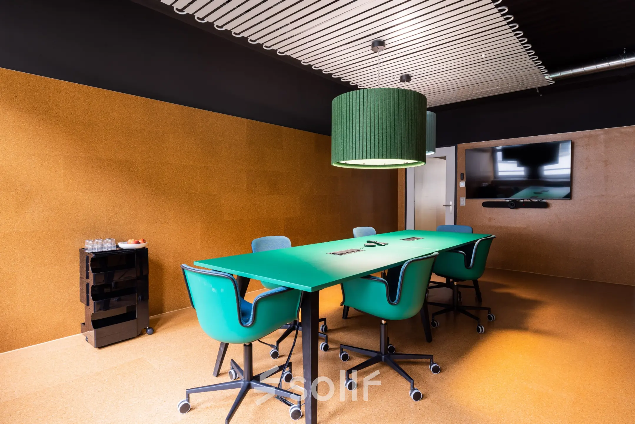 Stylish conference room at Uraniastrasse 31, Zürich Center, featuring vibrant green chairs and a large table, ideal for office space rental.