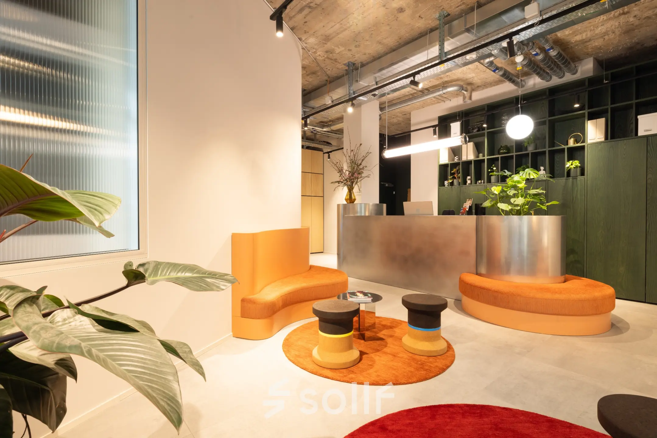 Modern reception area with orange seating and a sleek metal desk at an office space rental on Beethovenstrasse 48, Zürich Enge.