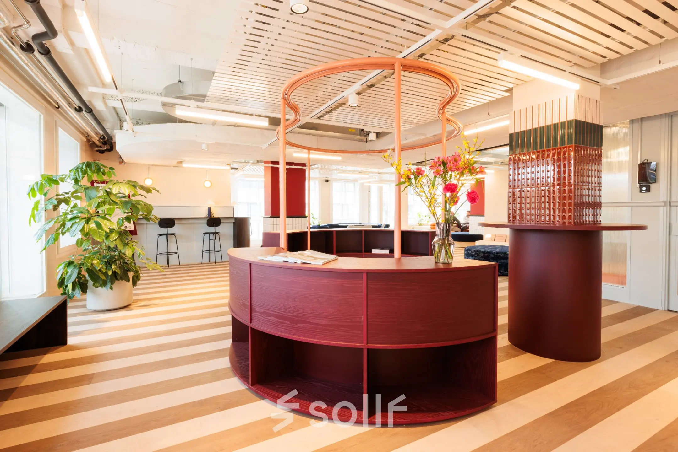 Modern furnished office space for rent at Stockerstrasse 33, Zürich Enge, featuring stylish curved furniture and vibrant decor with greenery, promoting a dynamic work environment.