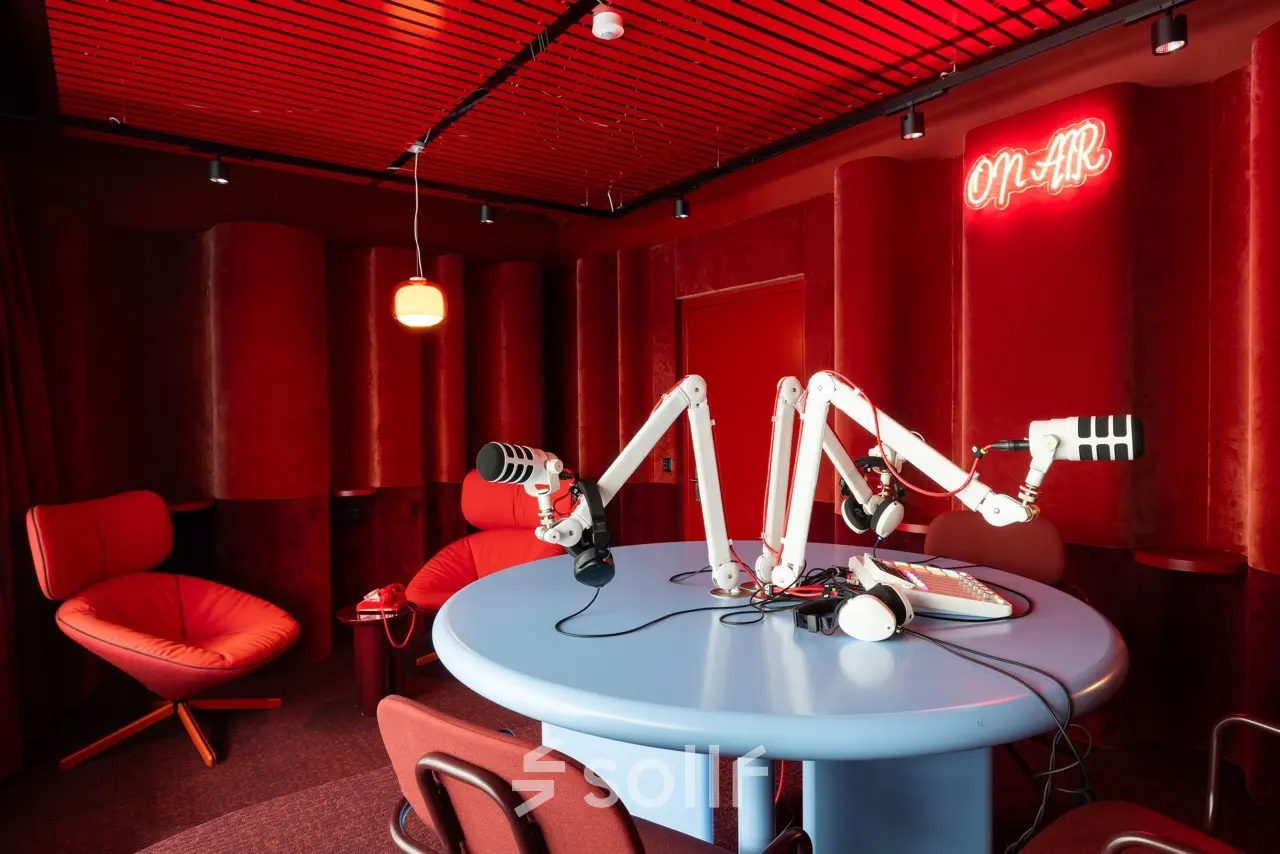 Vibrant office space at Stockerstrasse 33, Zürich Enge, featuring cozy seating and professional podcast recording equipment.