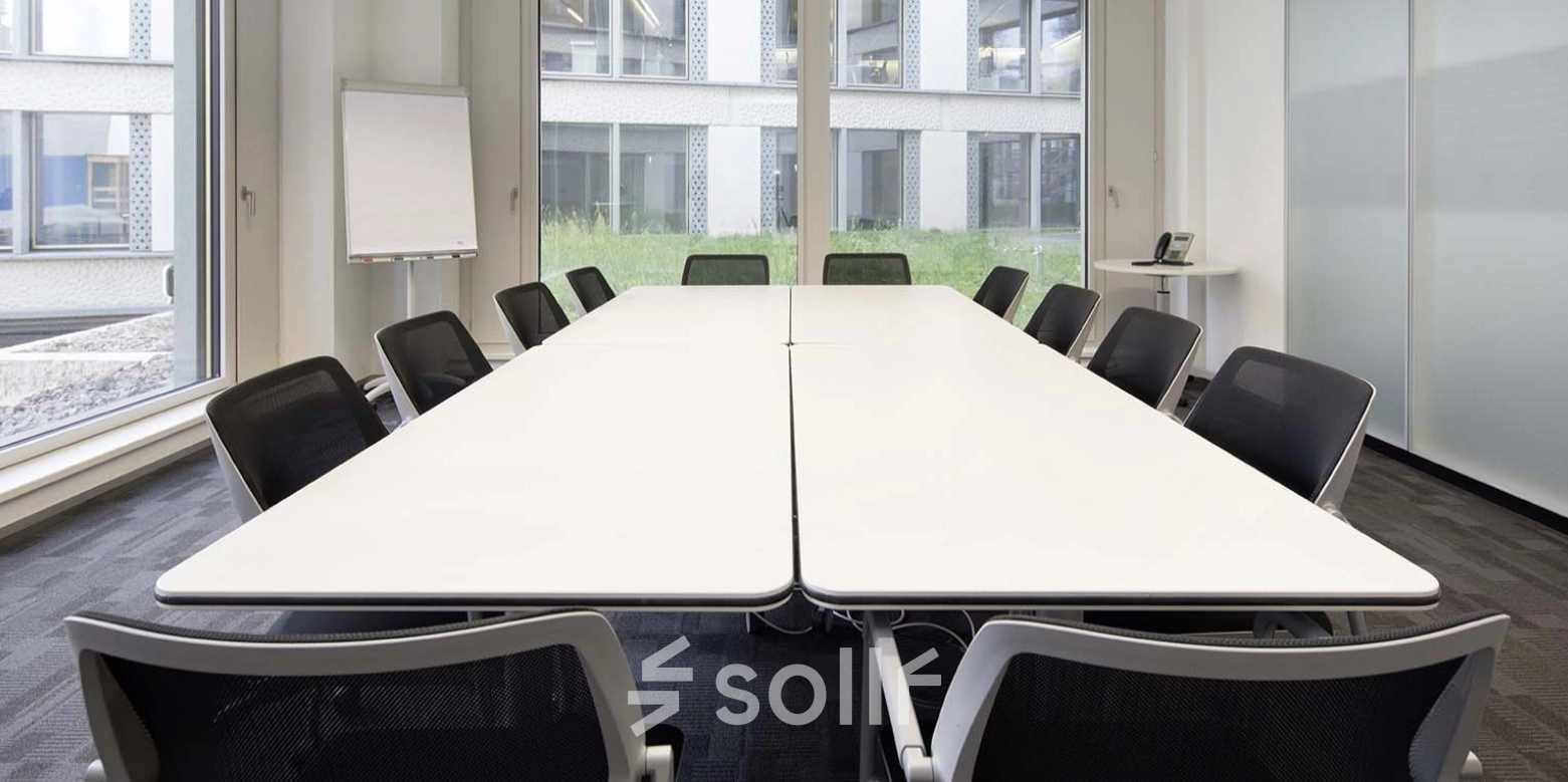 Office conference room at Europaallee 41, Zürich Mitte, featuring a central table, modern chairs, and large windows. Ideal for office space rental.
