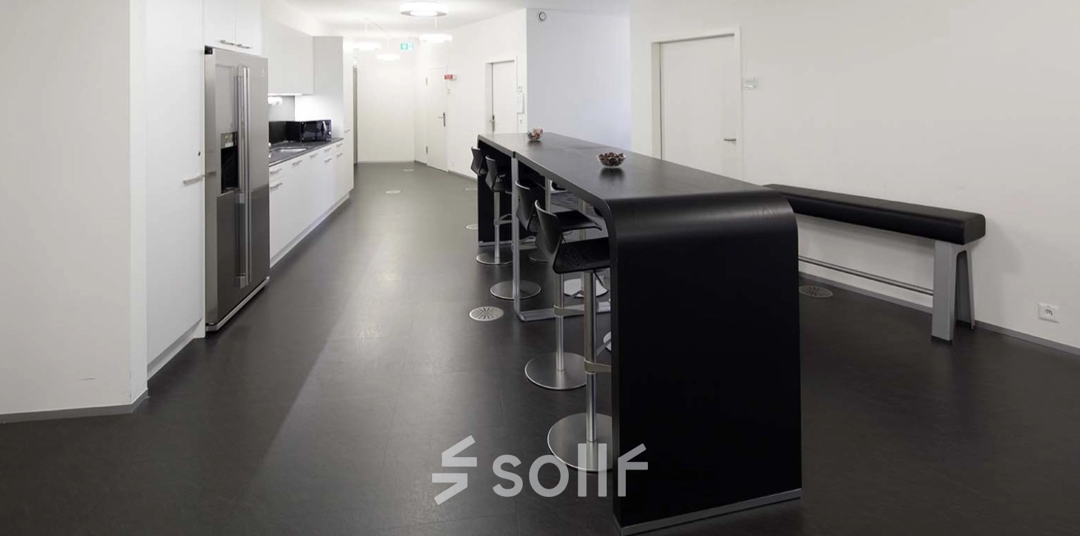 Modern office space with sleek kitchen facilities and high-top seating at Europaallee 41, perfect for office space rental in Zürich Mitte.