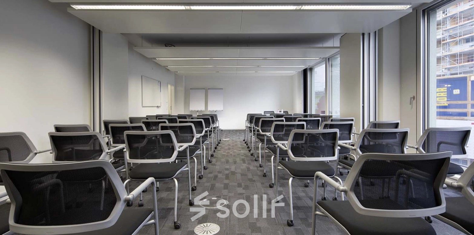 Modern office space with rows of chairs facing whiteboards and large windows, ideal for training sessions or presentations at Europaallee 41.
