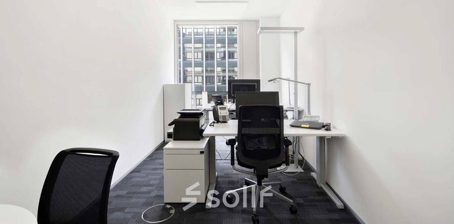 Bright and functional workspace available to rent at Europaallee 41, Zürich Mitte, featuring modern furnishings and ample natural light from large windows.