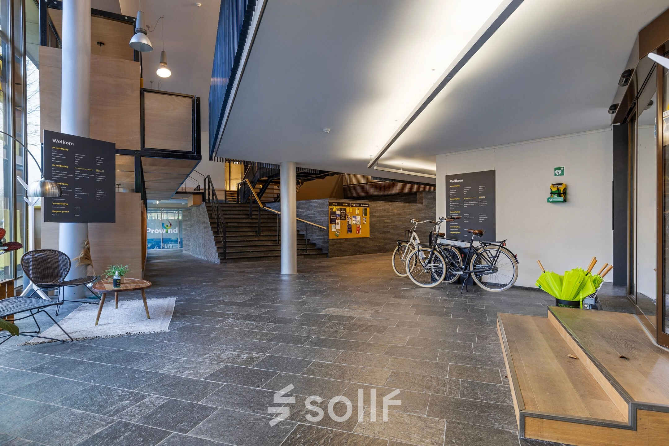Spacious entrance area at Assendorperdijk 1, Zwolle, ideal for office space rental, featuring a sleek modern design with bicycles parked nearby.