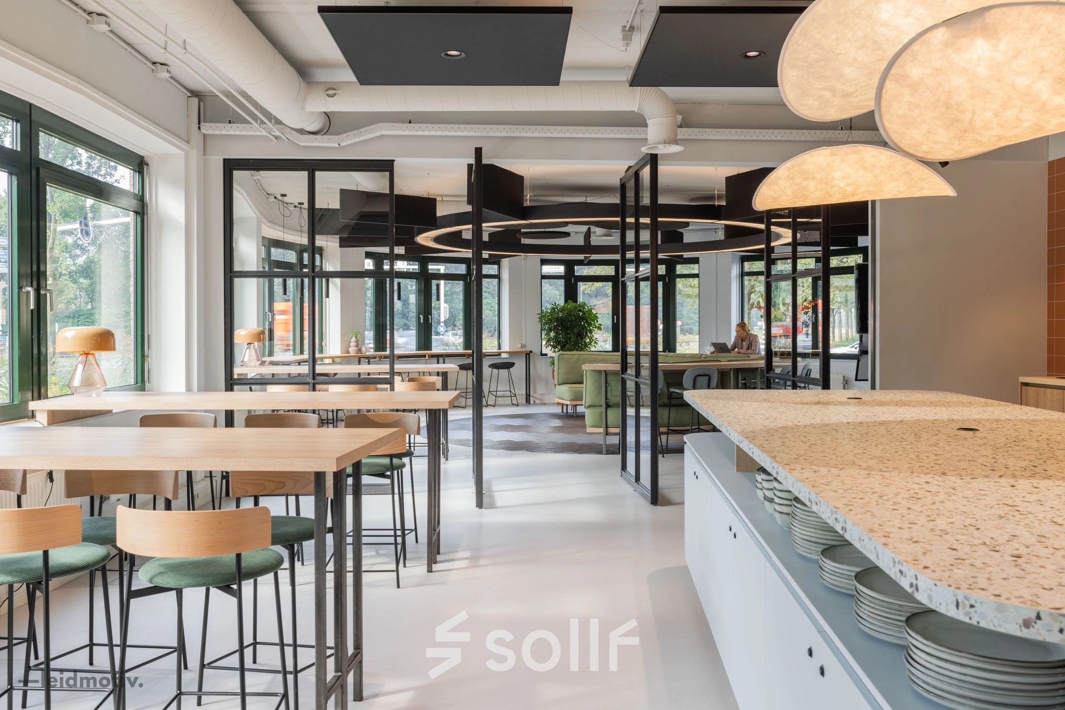 Modern office space with sleek tables and chairs, large windows, and stylish lighting at Hanzelaan 351-361. Ideal for those looking to rent office space in Zwolle.
